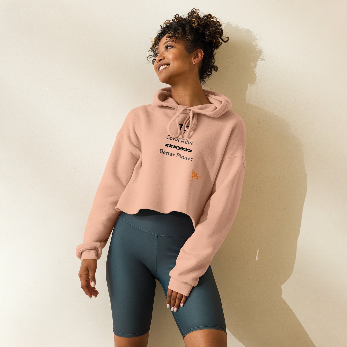 Activewear for women. Peach crop hoodie with a sustainable slogan 'Coral alive Better planet.'